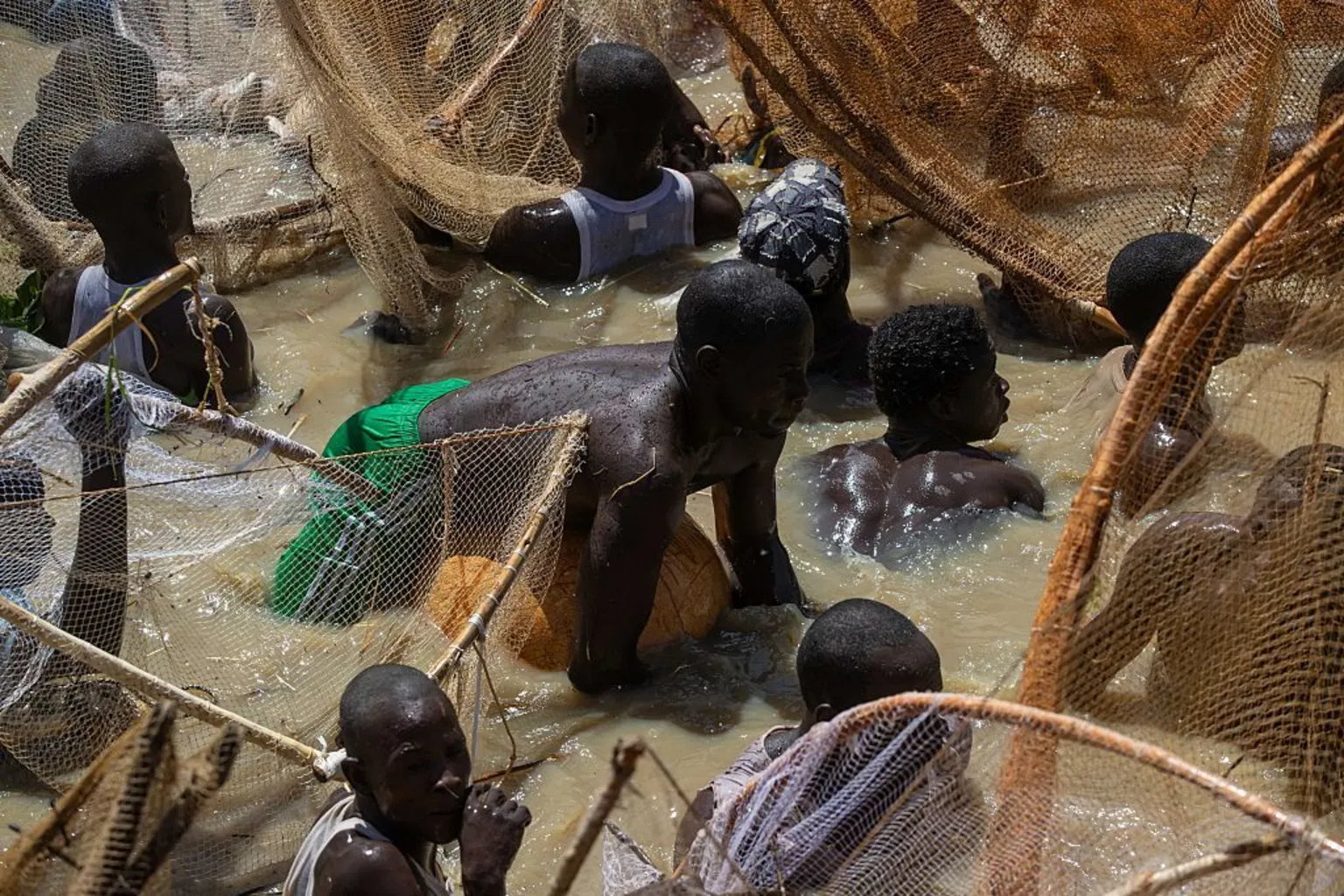 AFP via A crowded picture of fishermen in the water with one in the middle floating on a gourd.