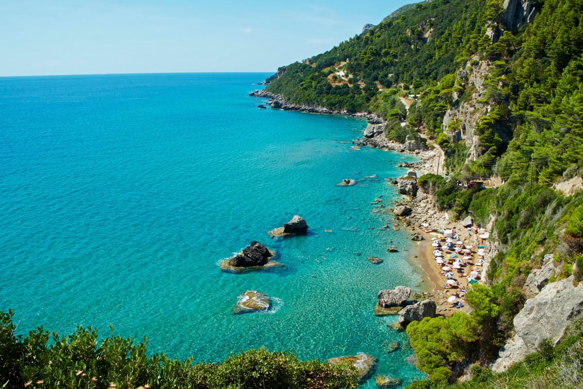 Tiny beach at foot of tall green cliffs