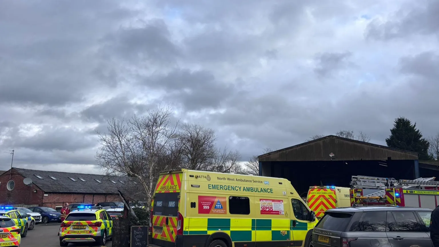 Supplied Multiple police, fire and ambulance service vehicles are parked at the farm, some with blue flashing lights.