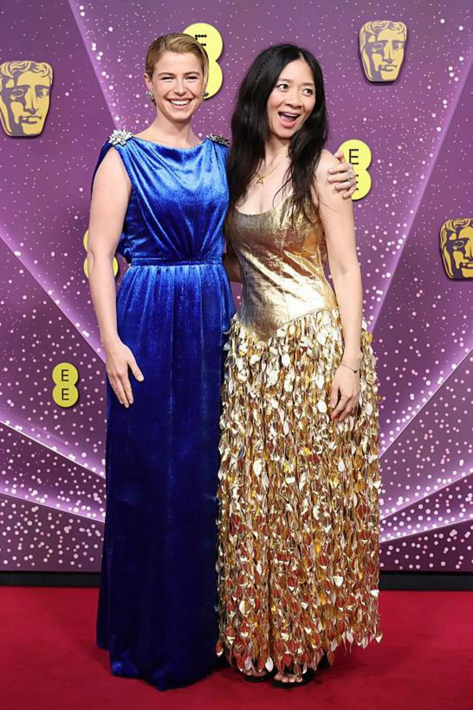 Jessie Buckley in a long blue dress and Chloé Zhao in a gold dress