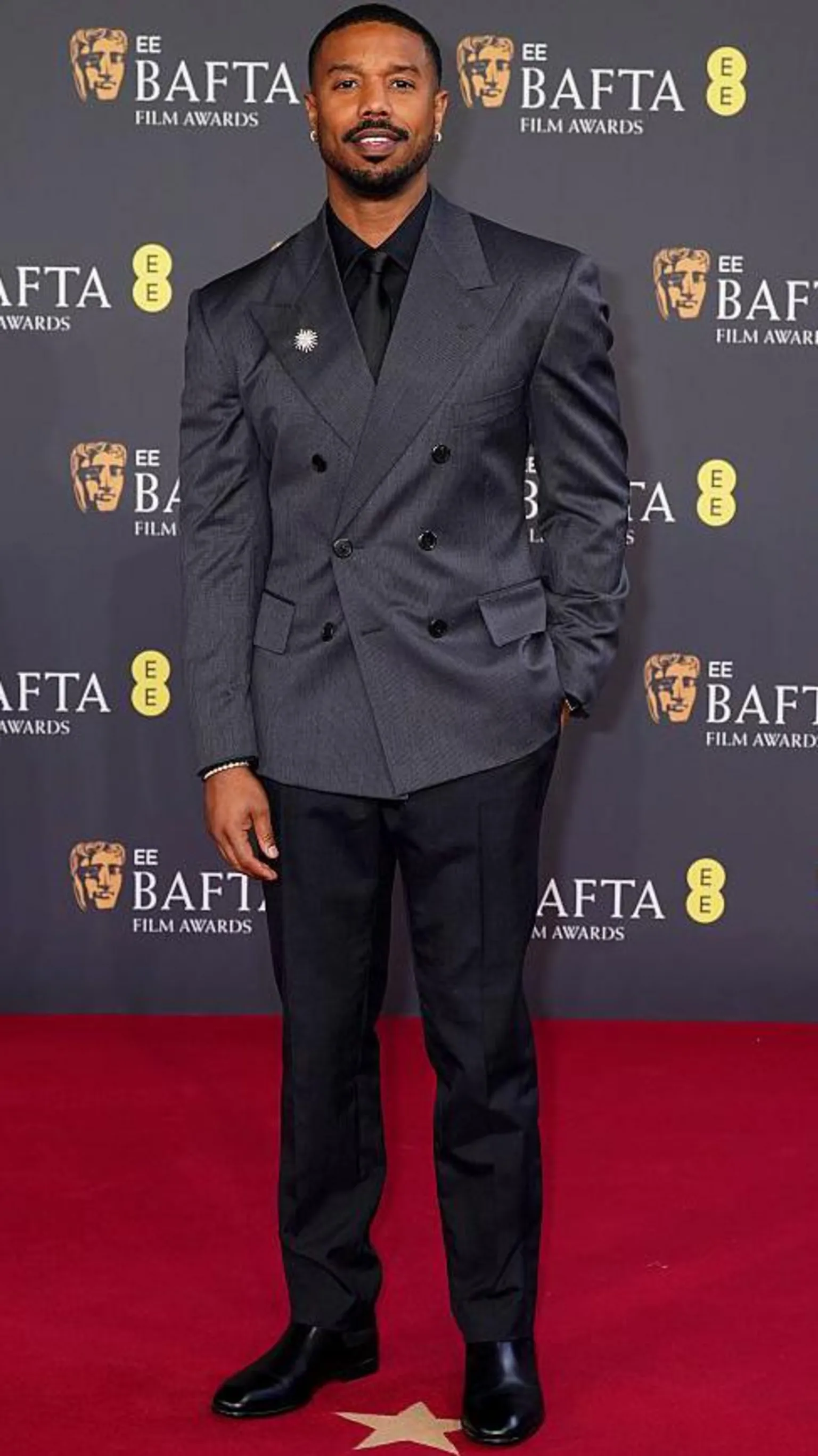  Michael B Jordan in a dark evening suit with brooch