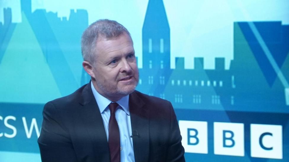 Llun Jeremy Miles yn siarad ar raglen BBC. Mae ganddo wallt llwyd ac mae'n gwisgo siwt du gyda chrys glas a thei marŵn
