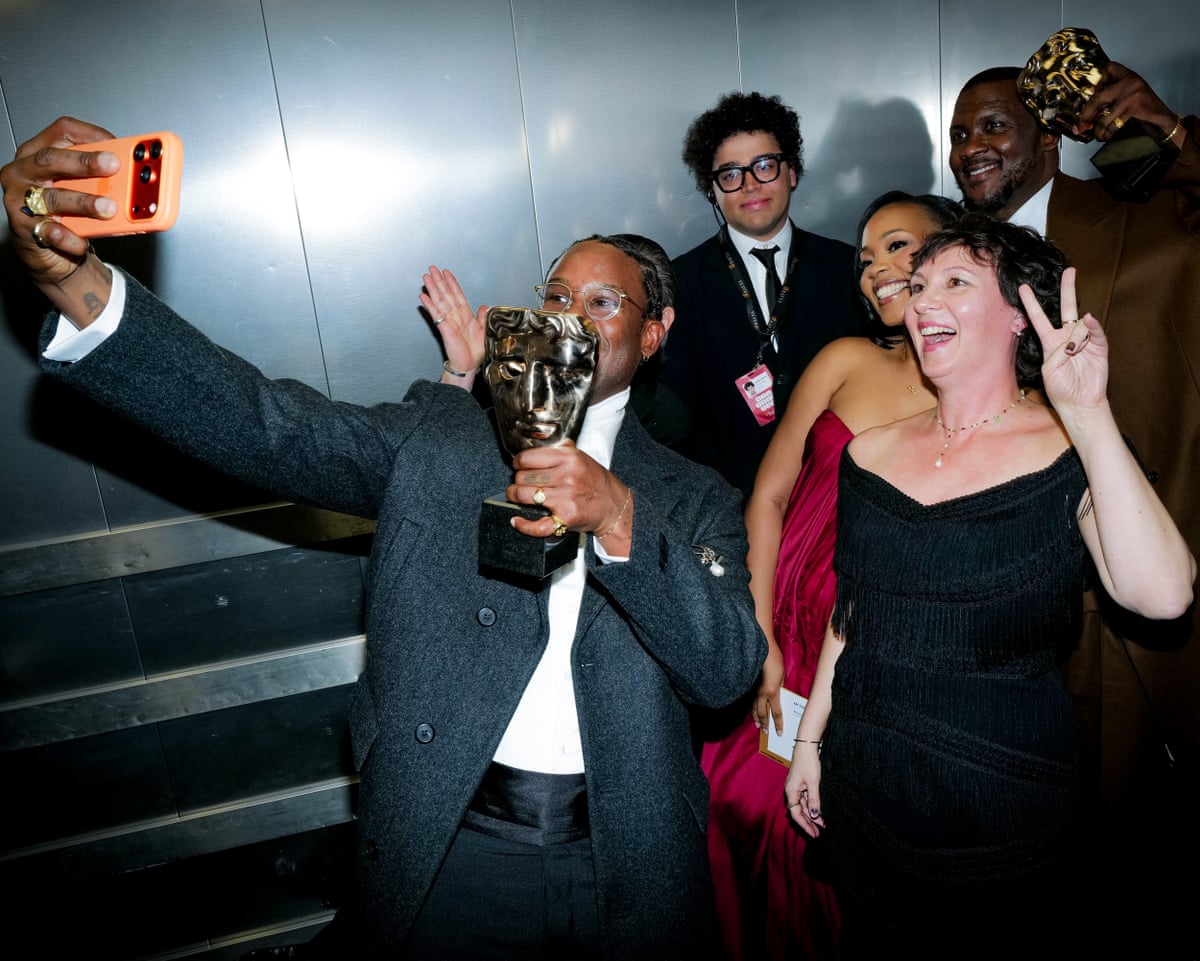 Akinola Davies Jr (left) holds the awad for outstanding debut by a British writer with Rachel Dargavel and Wale Davies at the Baftas.