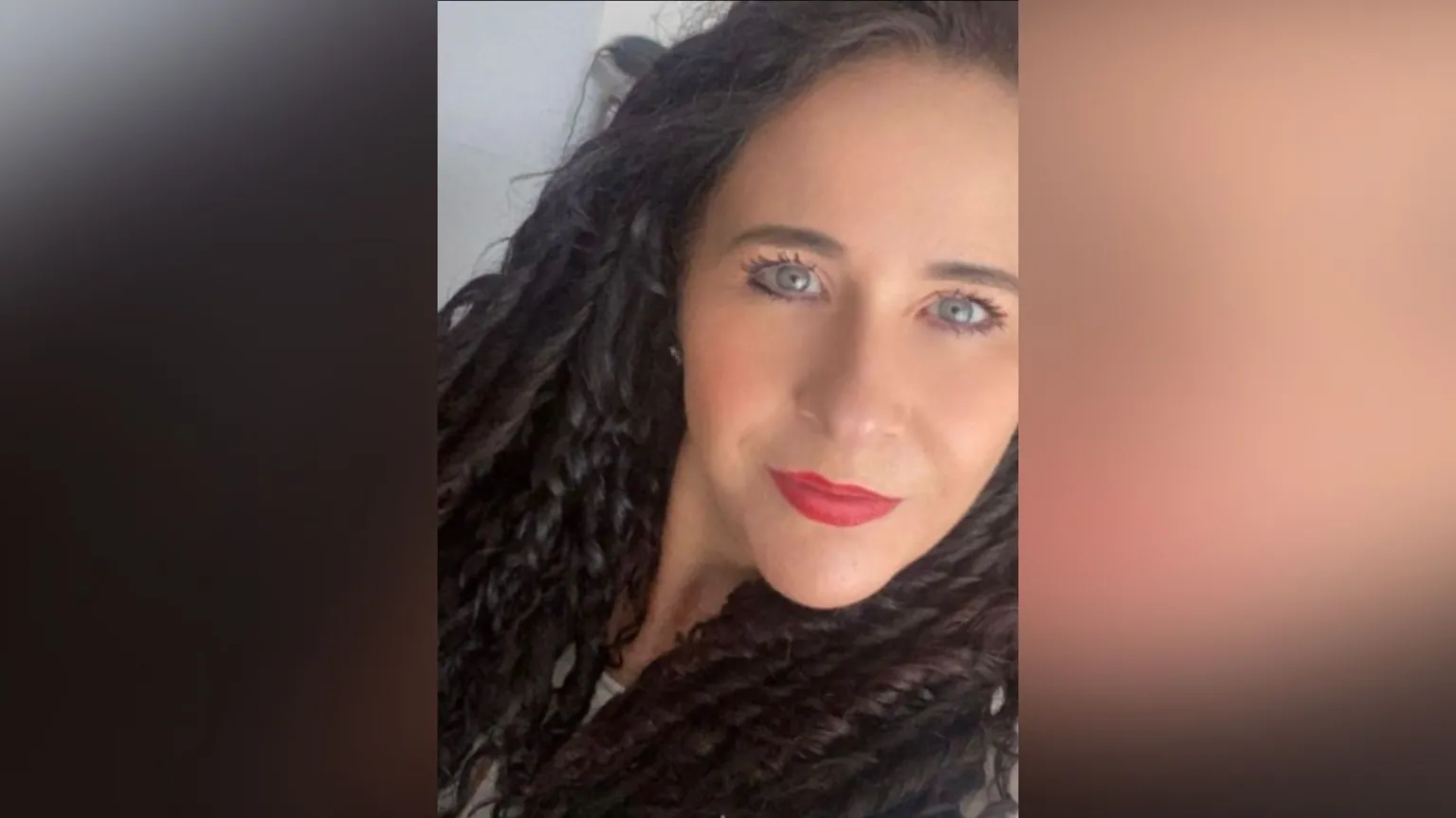 Carla Oakshott A selfie-style image of Carla Oakshott who is smiling at the camera. She has long dark hair that is curled tightly.