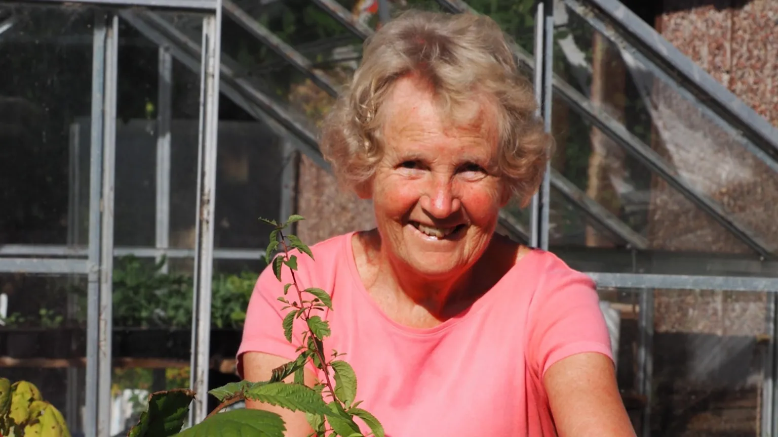 Supplied Janet Willonfer smiles for the camera on a sunny day. She is wearing a pink t-shirt and standing outside a greenhouse, with the top of a tree visible in front her