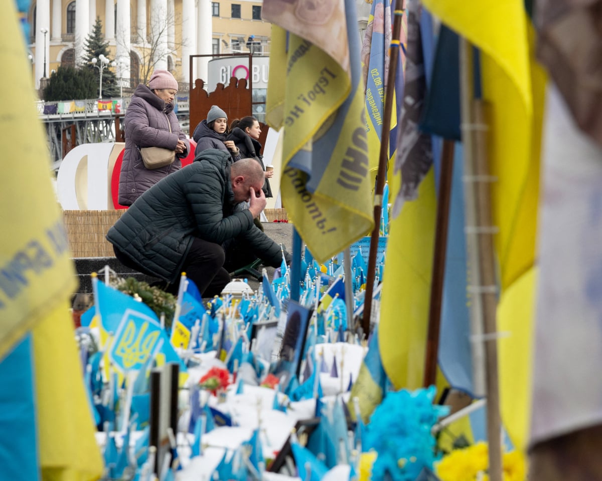 A local resident visits a makeshift memorial for Ukrainian and foreign soldiers in Independence Square in Kyiv, Ukraine.