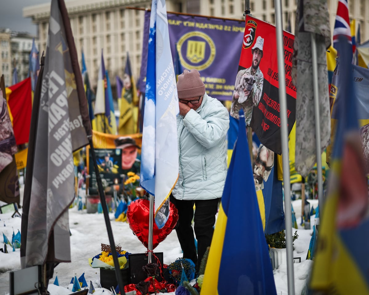 A local resident reacts visiting a makeshift memorial for Ukrainian and foreign soldiers in Independence Square in Kyiv, Ukraine.