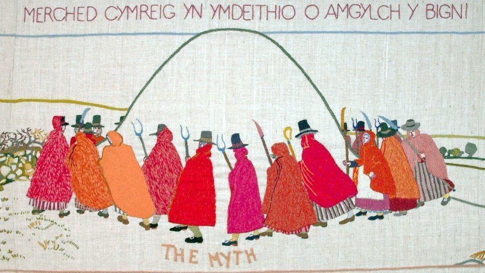 Merched mewn clogynnau coch ar dapestri