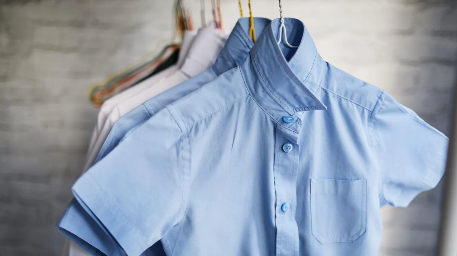  A row of blue and white shirts hanging up