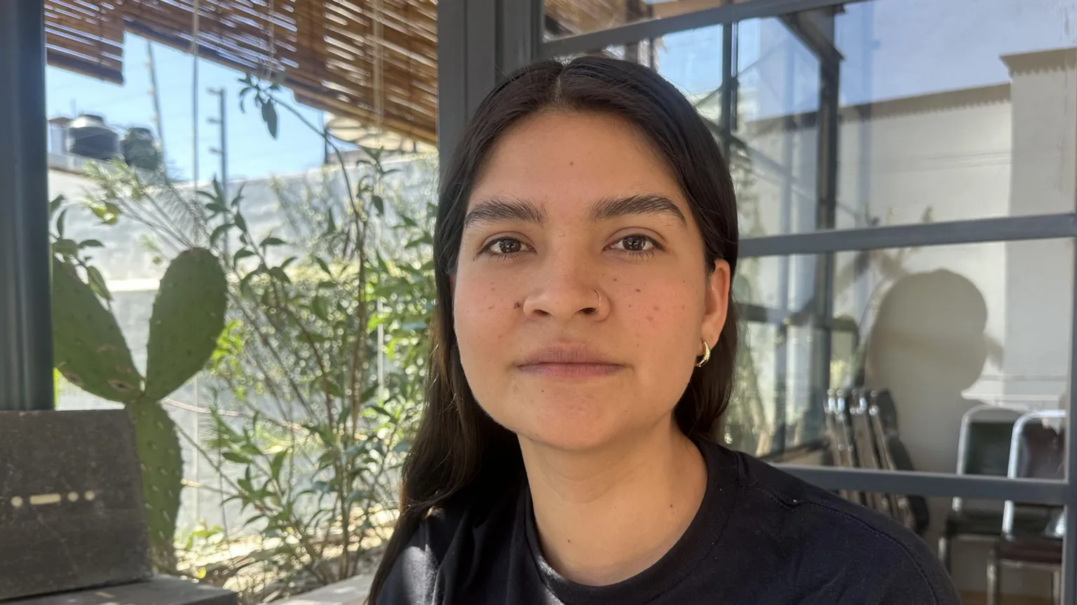 Local representative, Mariana Casillas, sitting outside wearing a black t-shirt