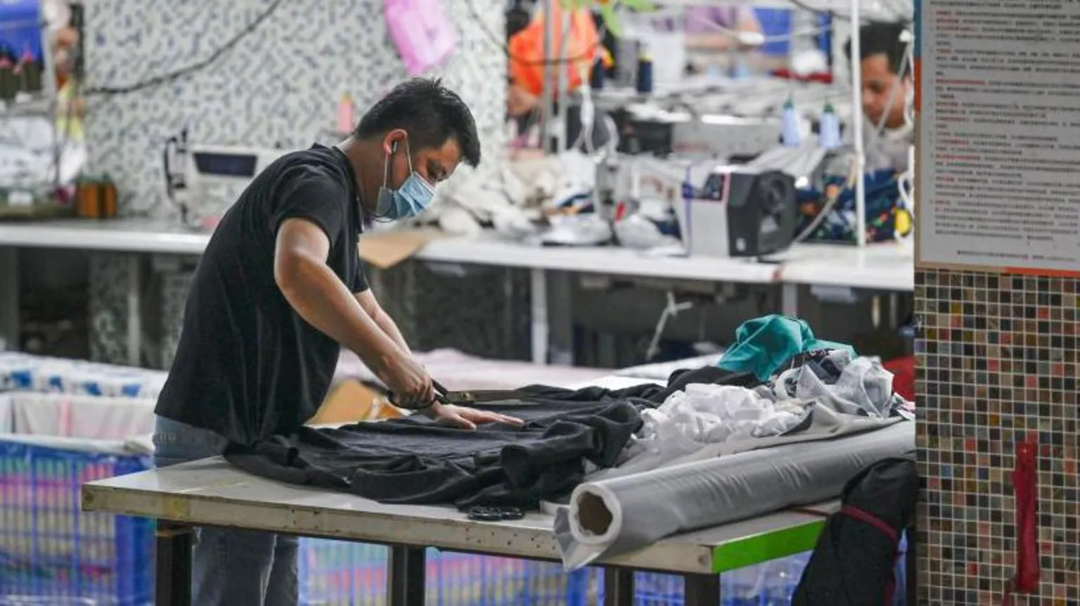  A worker holding a pair of large scissors while producing clothes at a Guangzhou textile factory that supplies clothes to fast fashion e-commerce company Shein 