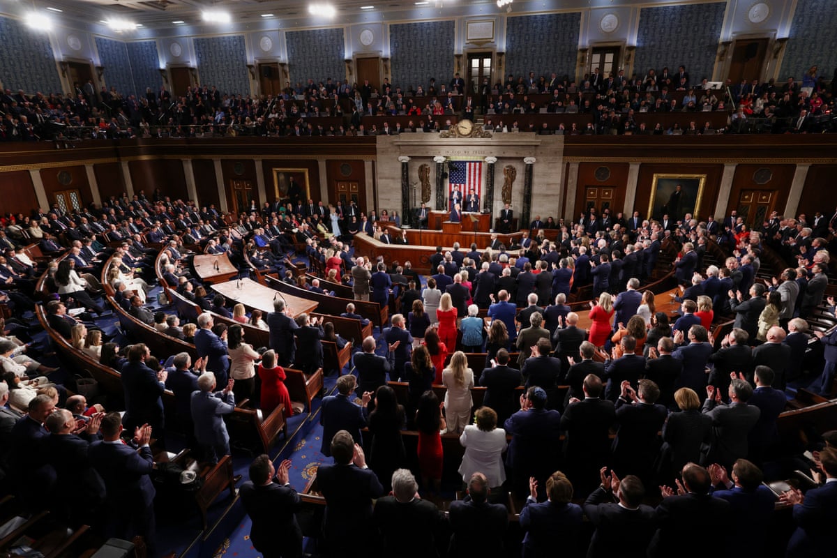 People sit and stand in chamber