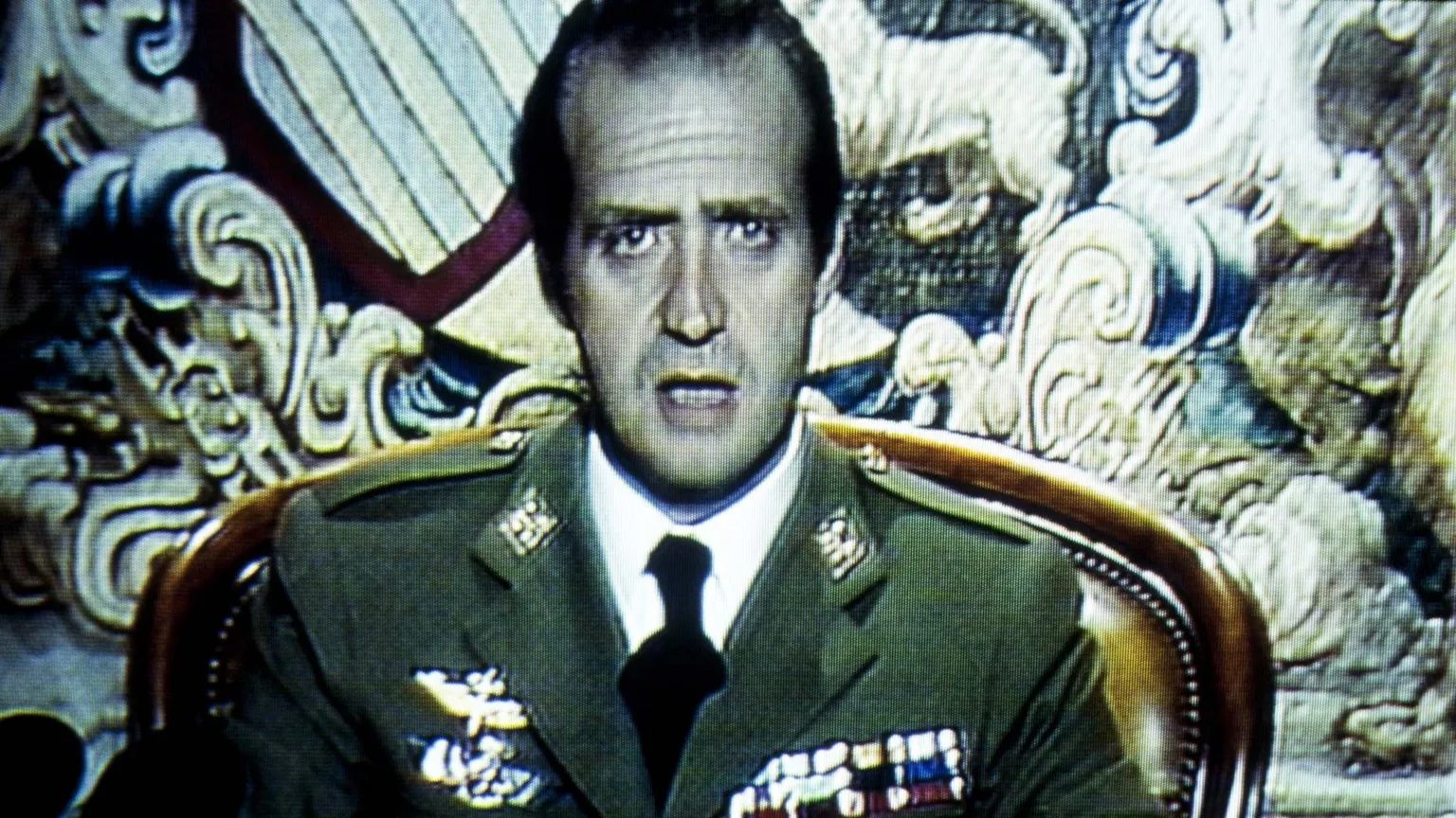 King Juan Carlos wearing green military uniform, white shirt and black tie, sits with mouth open during his address of 23 February 1981.
