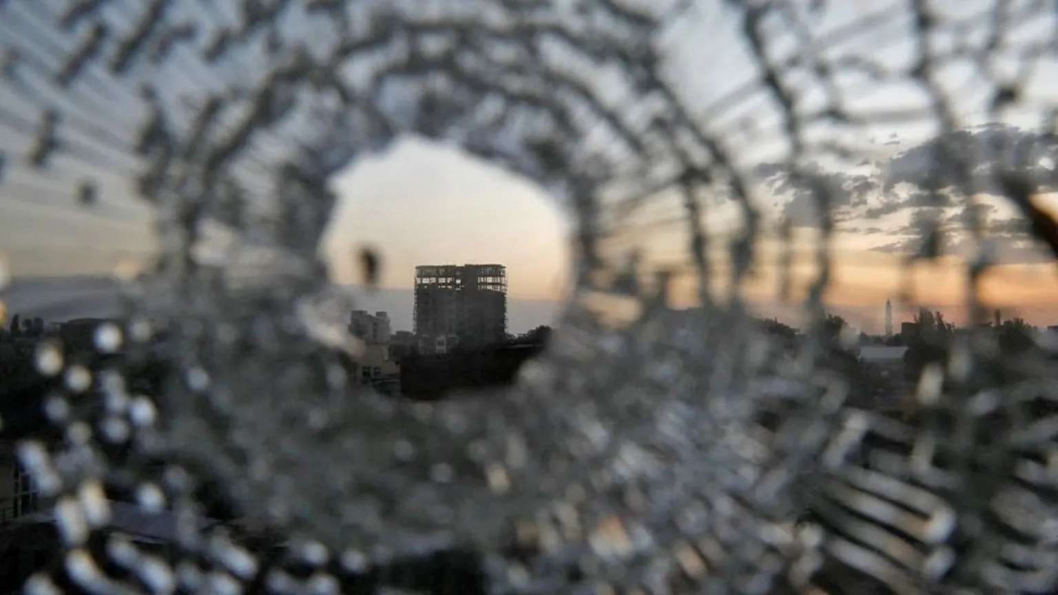  A building seen through shattered glass caused by artillery in Shire.