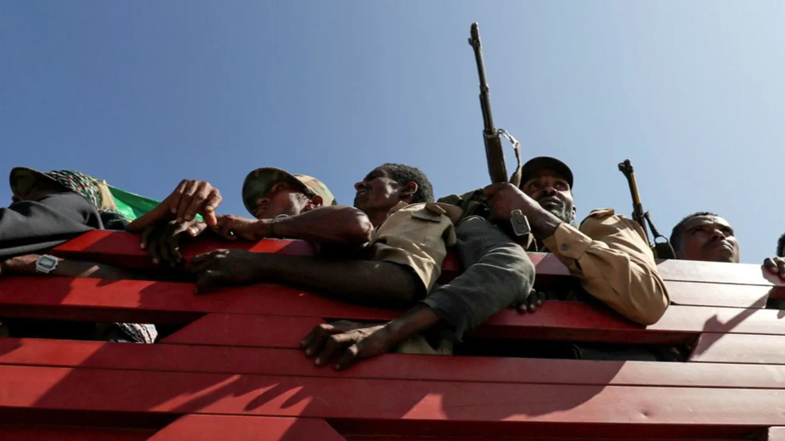  Armed Amhara fighters in khaki uniforms seen aboard a red truck