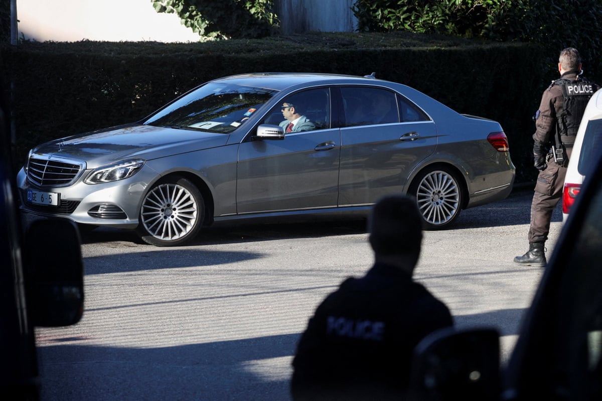 A car carrying the Iranian delegation drives past officers.