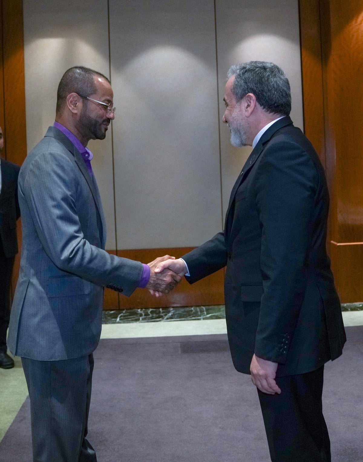 Omani foreign minister Badr Albusaidi and Iran’s foreign minister Abbas Araghchi shake hands.