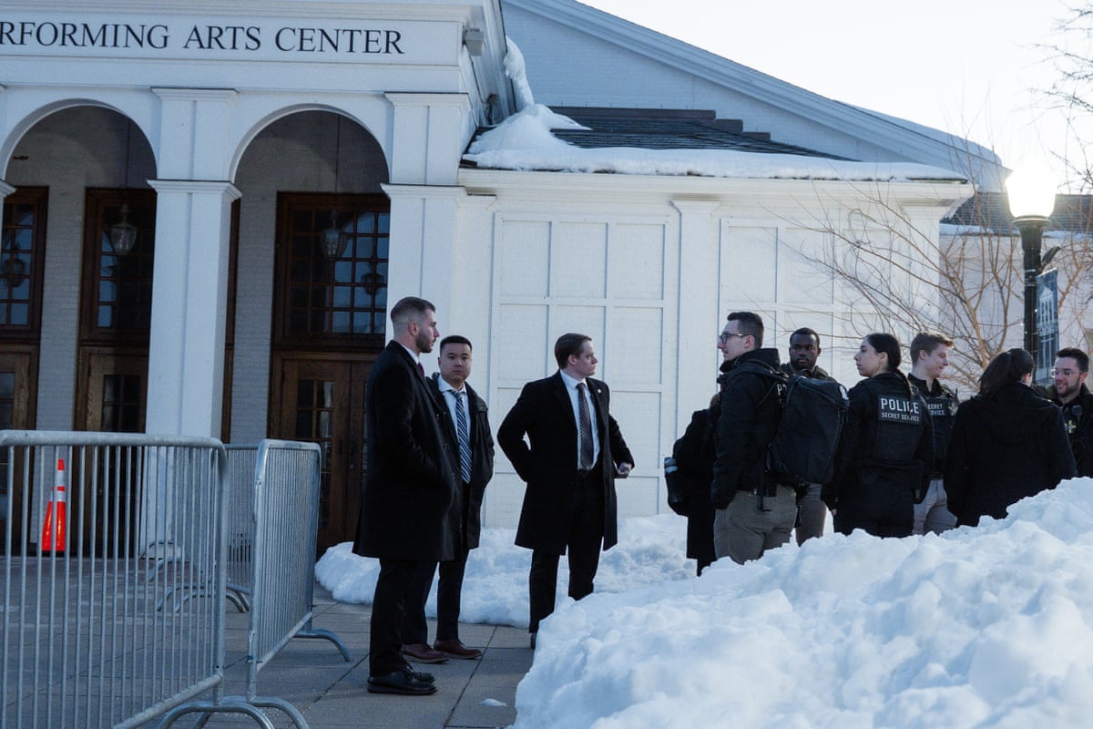 law enforcement officers stand outside a building