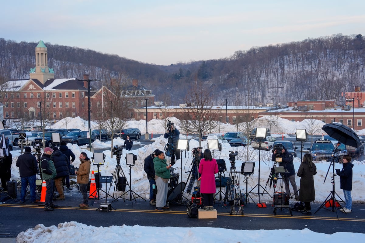 people with news cameras stand outside