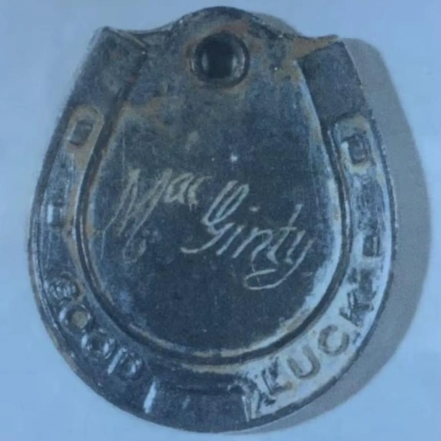 An Garda Síochána A picture of a horseshoe medal with MacGinty inscribed on it.