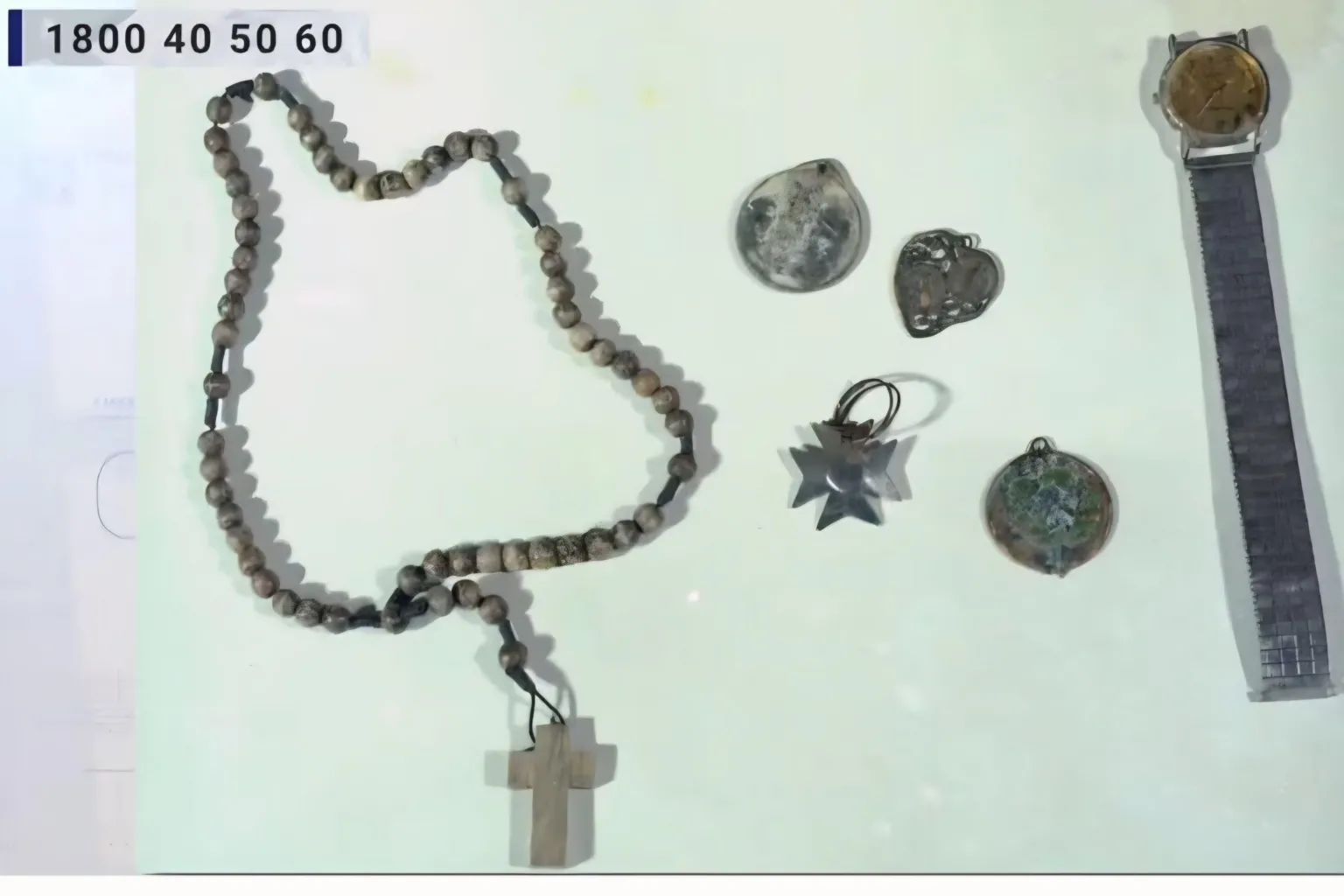 An Garda Síochána A picture of Wooden Rosary beads, a keyring with three religious medals and a Silver Philip Mercier watch with a gold face