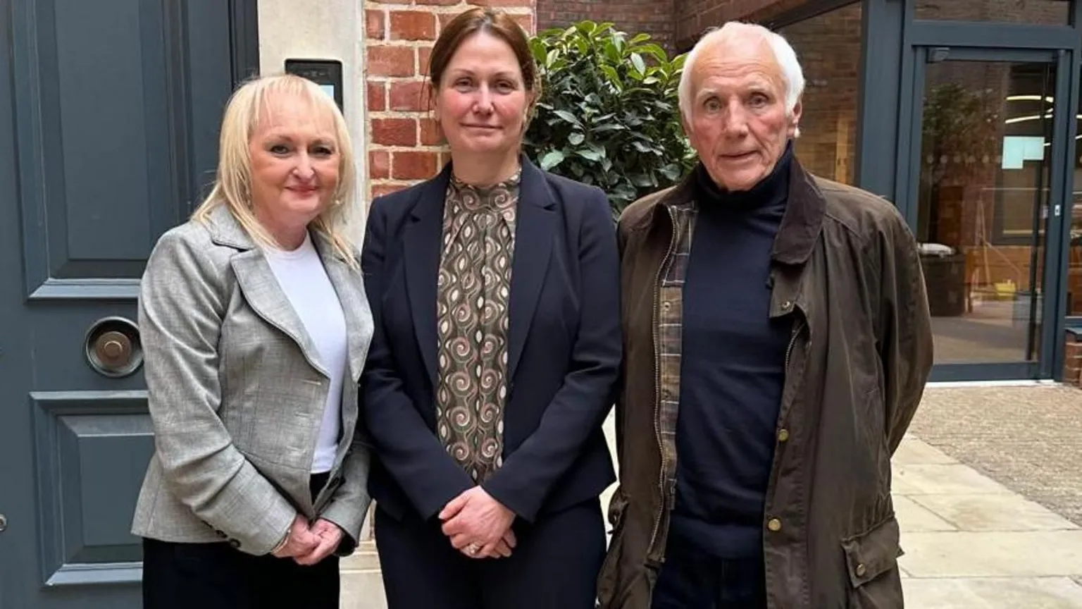 Tim Reid Media Jenni Hicks, who has blonde hair and is wearing a grey blazer over a white t-shirt, Lauren Poultney who has brown hair and is wearing a navy suit jacket over a patterned blouse and Trevor Hicks, who has white hair, a brown coat and a blue roll neck jumper. 