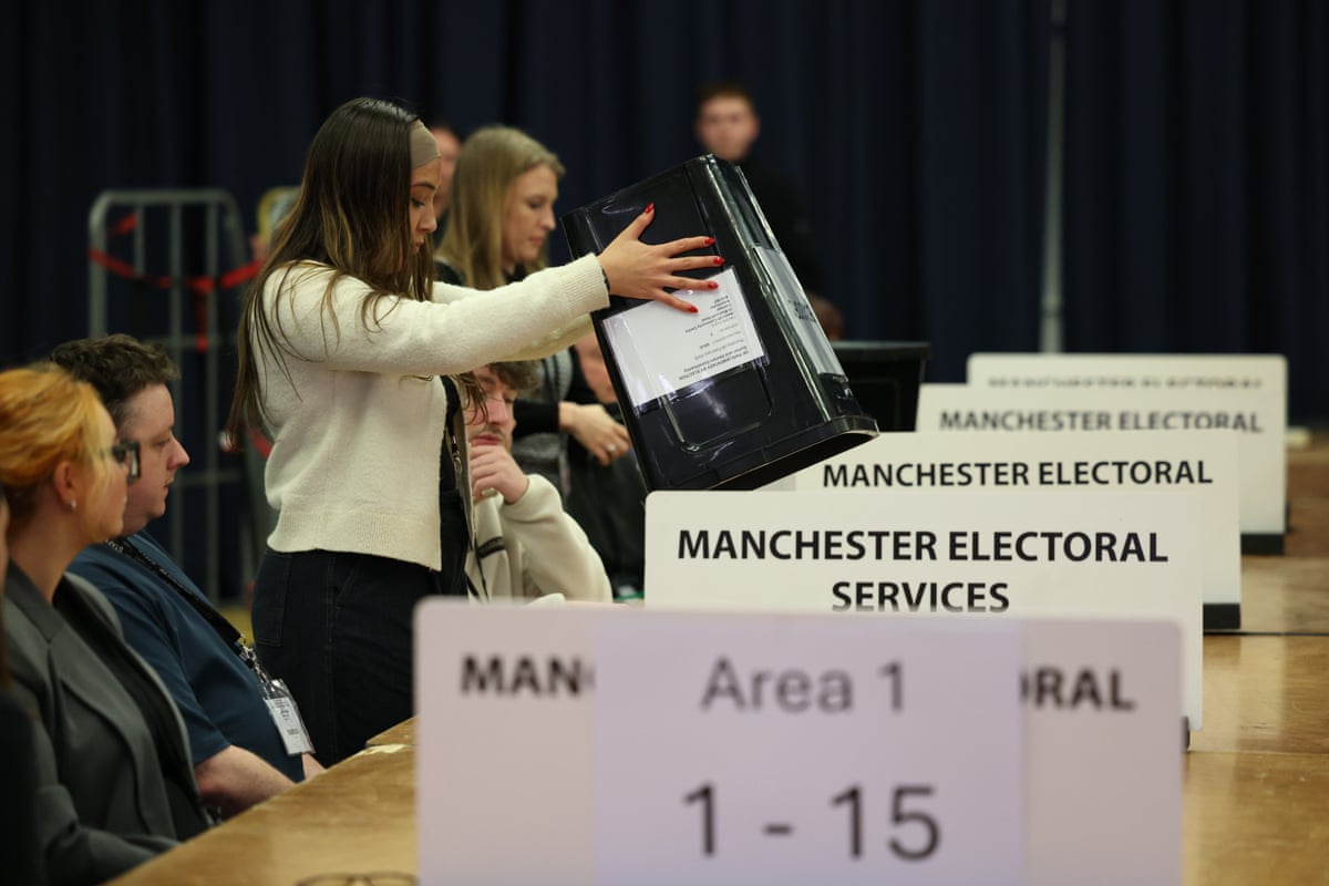 Ballot papers are tipped out of boxes during the vote count.