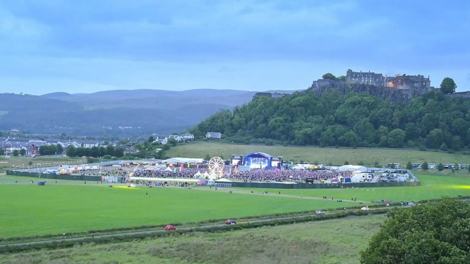 Stirling Council A large park with a stage in the middle and crowds. Stirling Castle is visible in the background