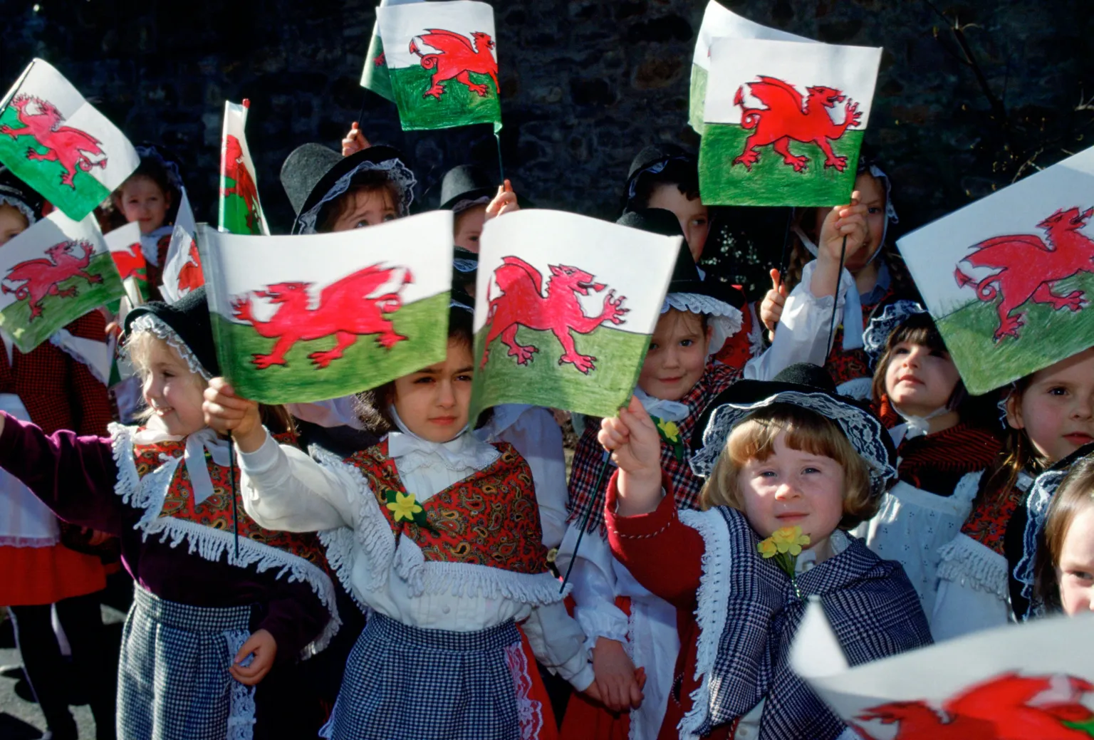Tim Graham Photo Library/ Children Gather In Wales To Meet Prince William On St David's Day. They Are Dressed In Traditional Welsh Costumes And Waving Flags.
