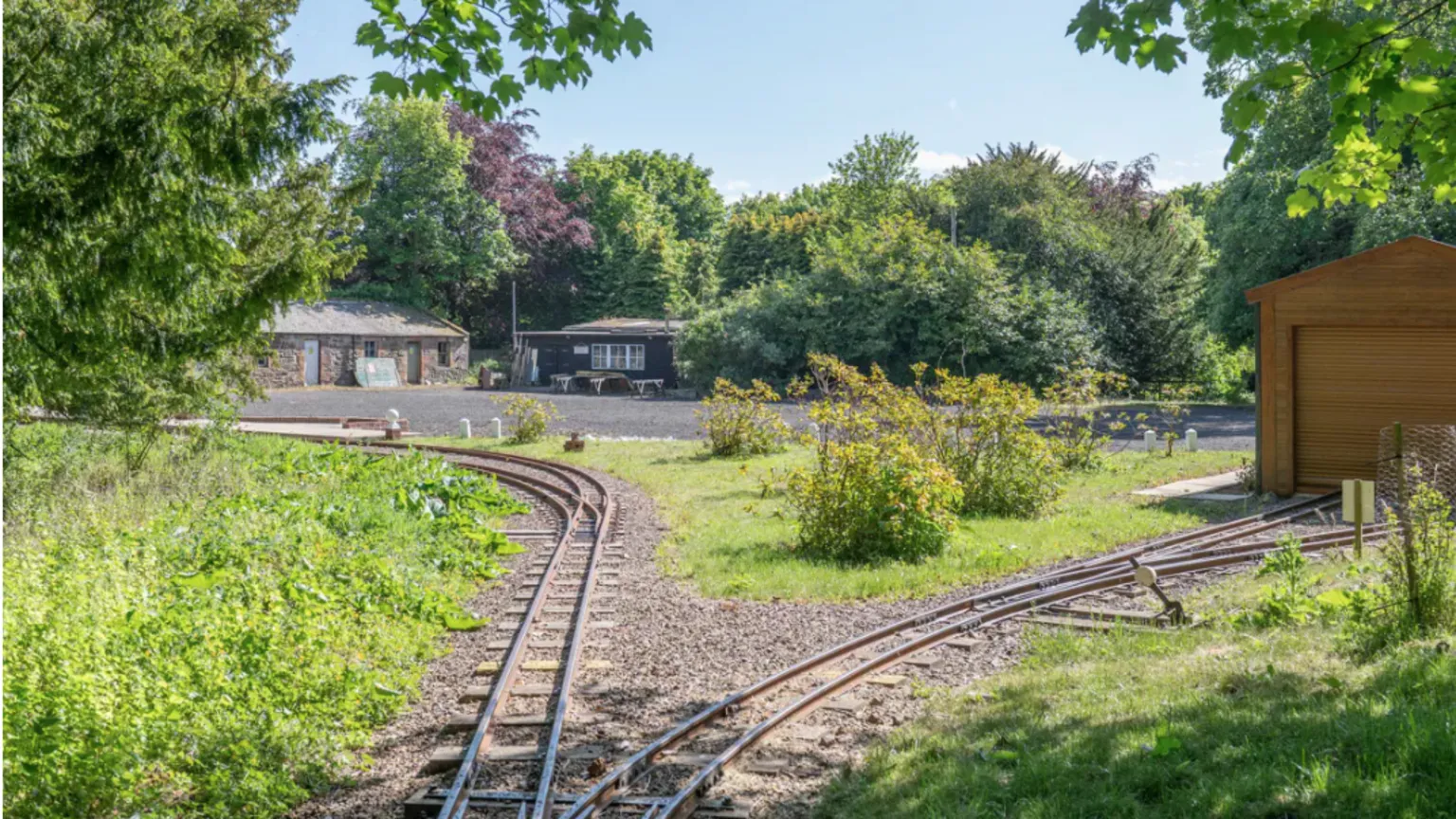 Knight Frank Narrow train tracks across a garden
