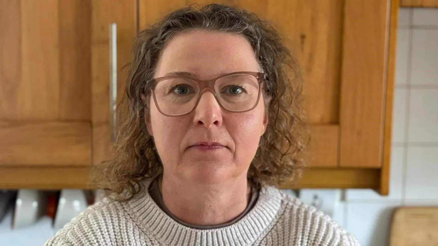 Victoria Fear Victoria Fear stands in a kitchen with a cabinet and bowls behind her.