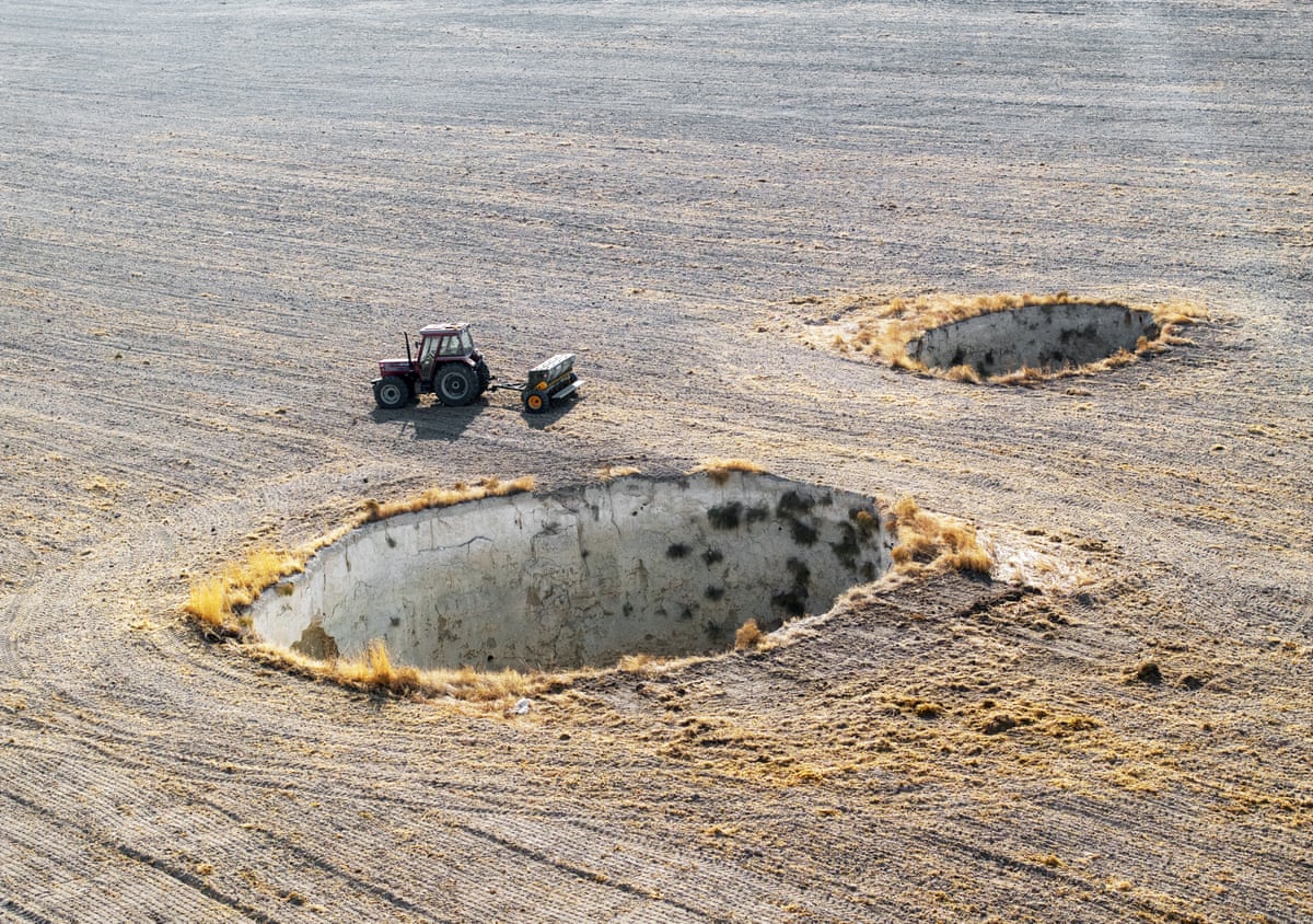 A tractor in a field of sinkholes