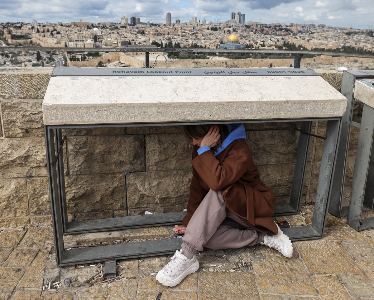 A person takes shelter as sirens sounded in Jerusalem.