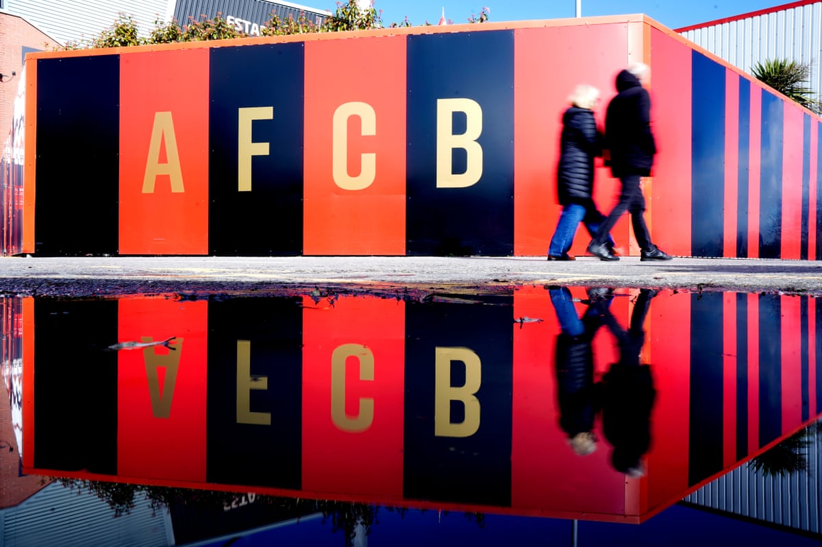 A couple of fans walk past the Vitality Stadium.