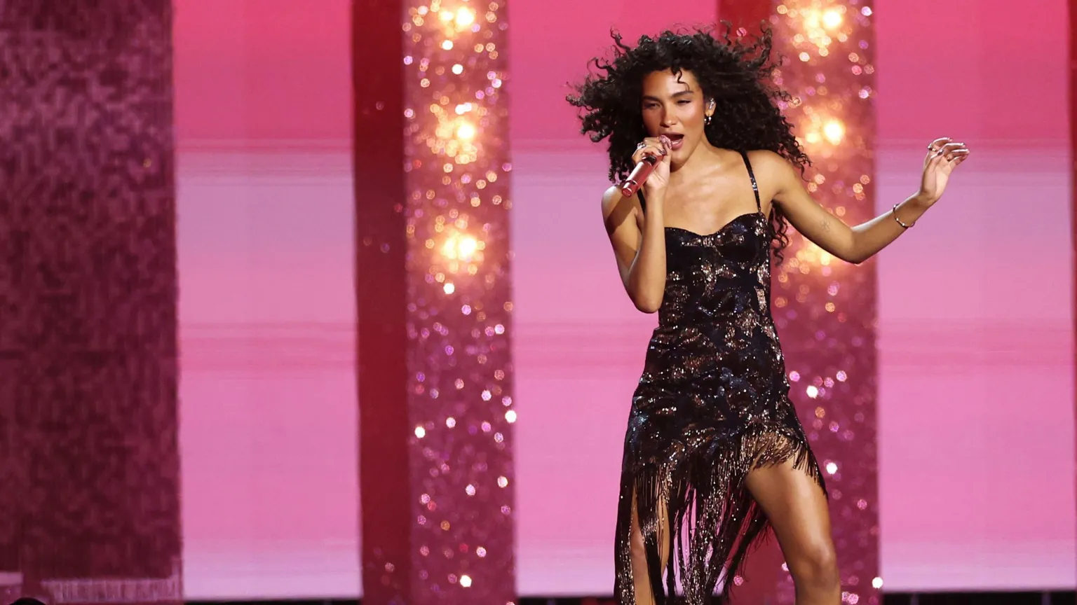 EPA/Shutterstock Olivia Dean performing at the Brits for fans while wearing a black dress