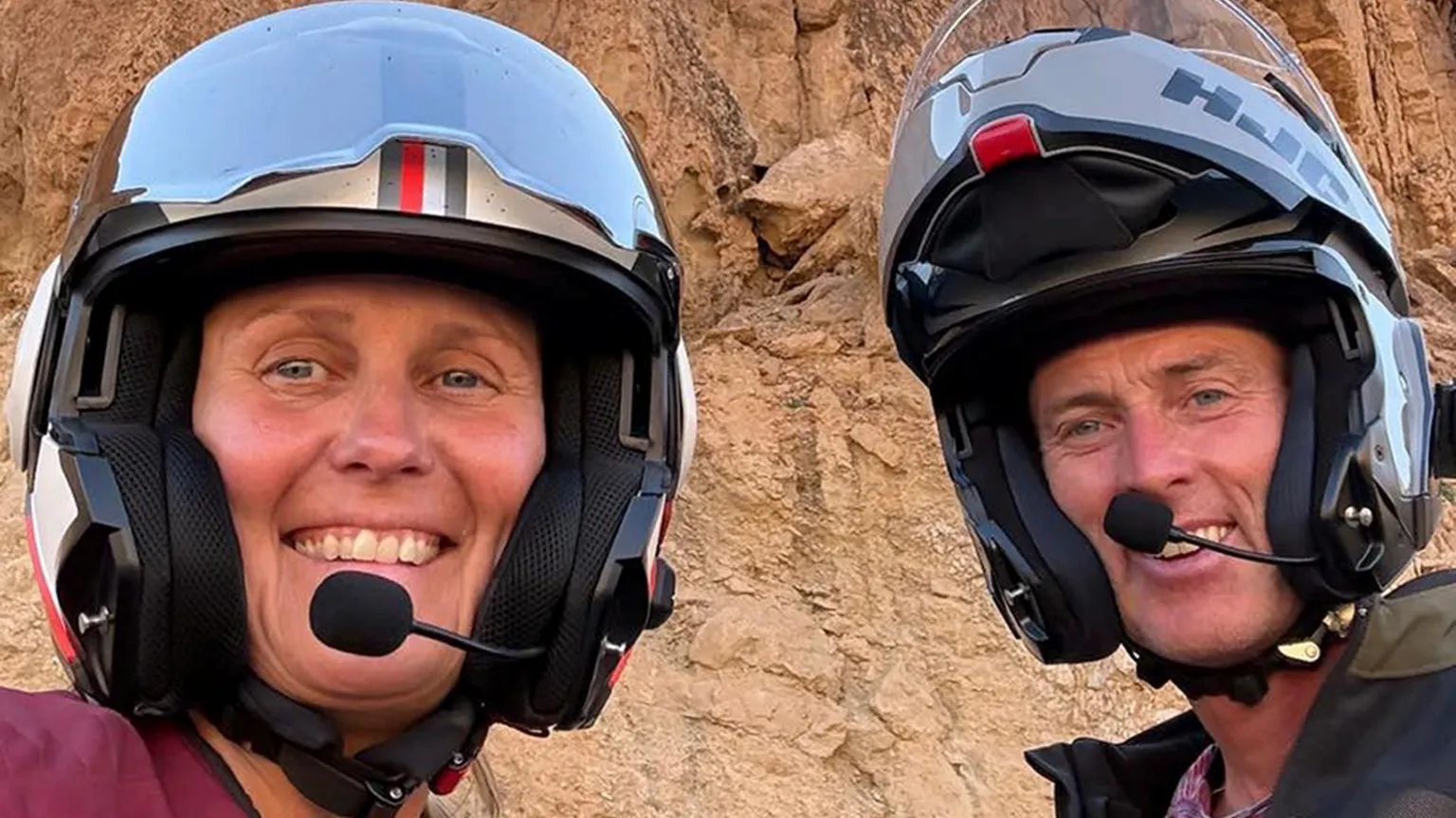  A husband and wife in motorcyle helments. 