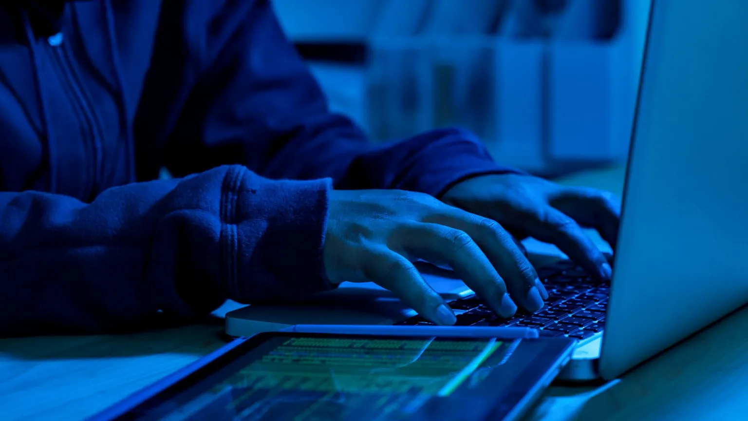  A mock-up of a cyber criminal typing into a laptop