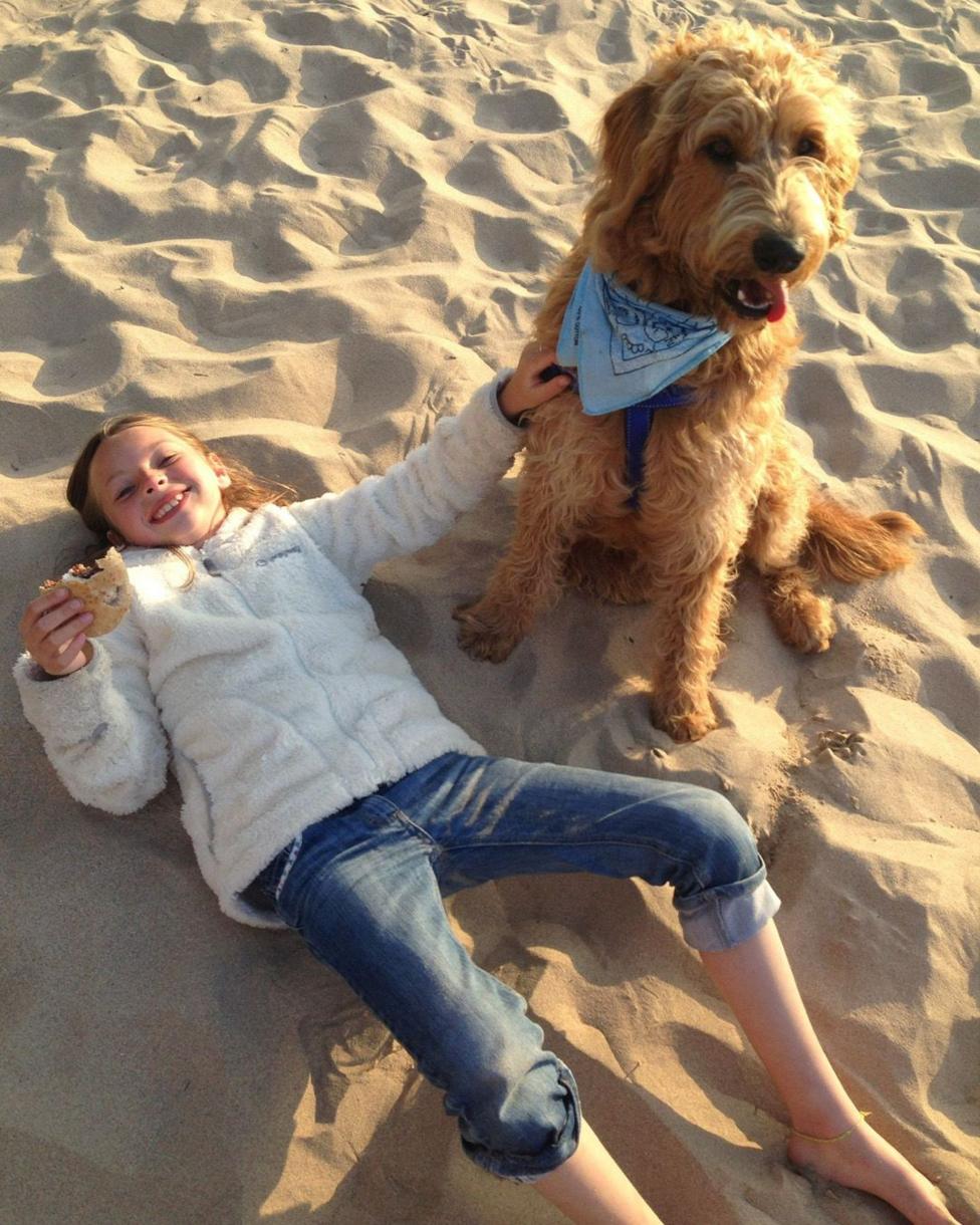 Ci a merch ar draeth 