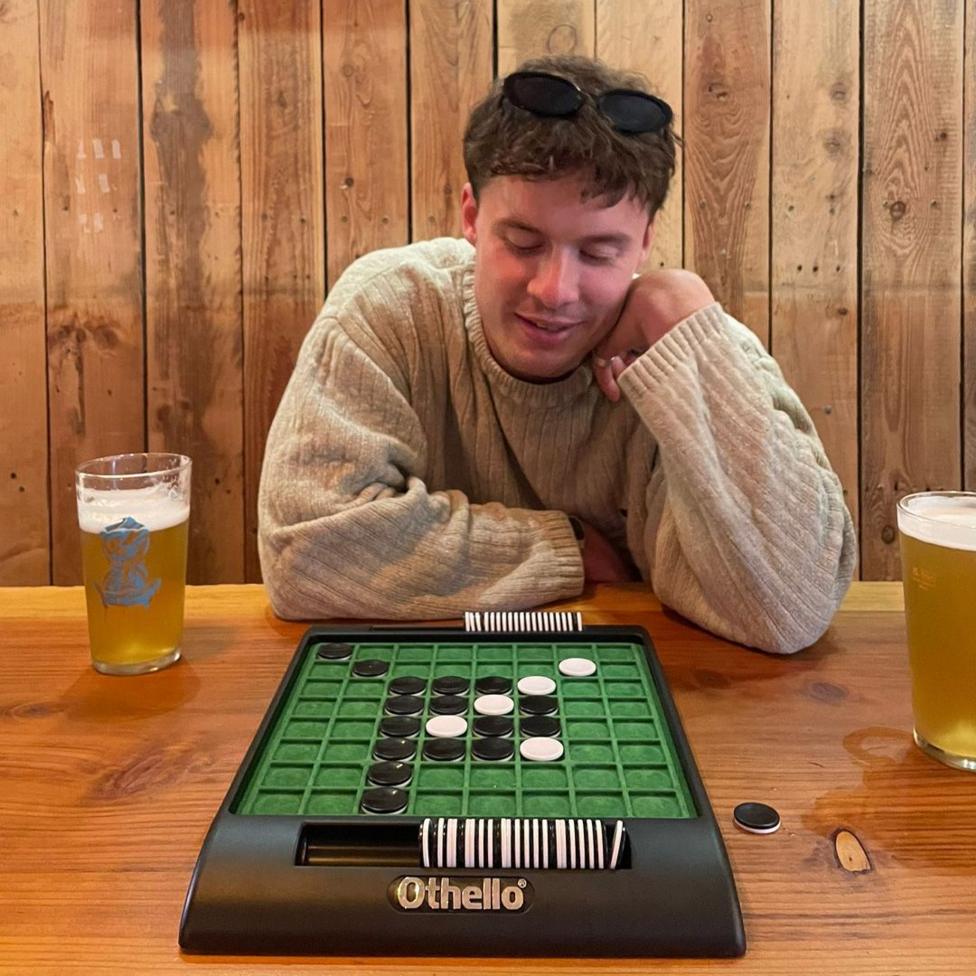 dyn yn chwarae gêm bwrdd