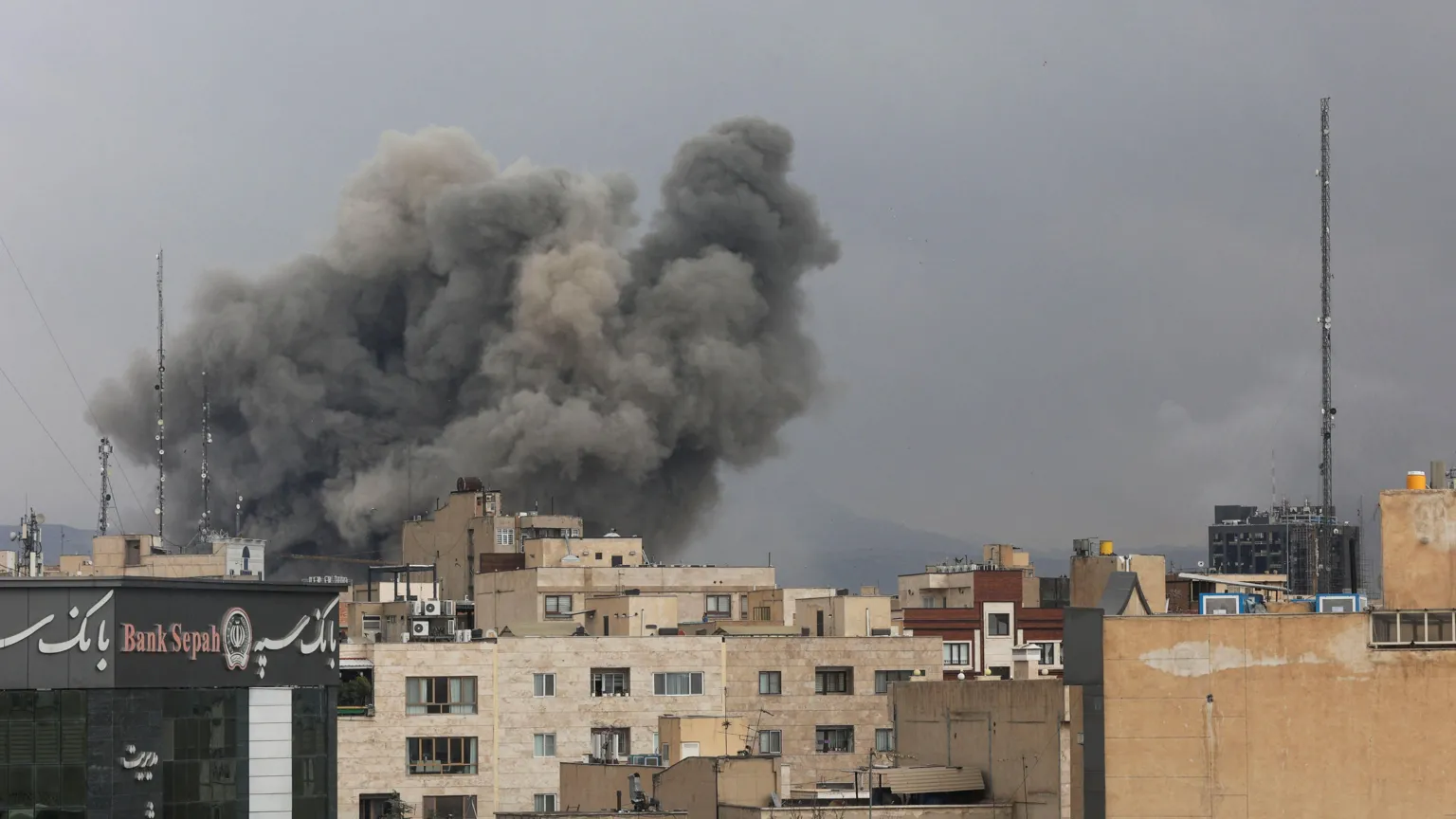  Smoke rising in the distance following an explosion in Tehran, Iran. Other buildings can be seen in the foreground. They have not been affected by missiles.