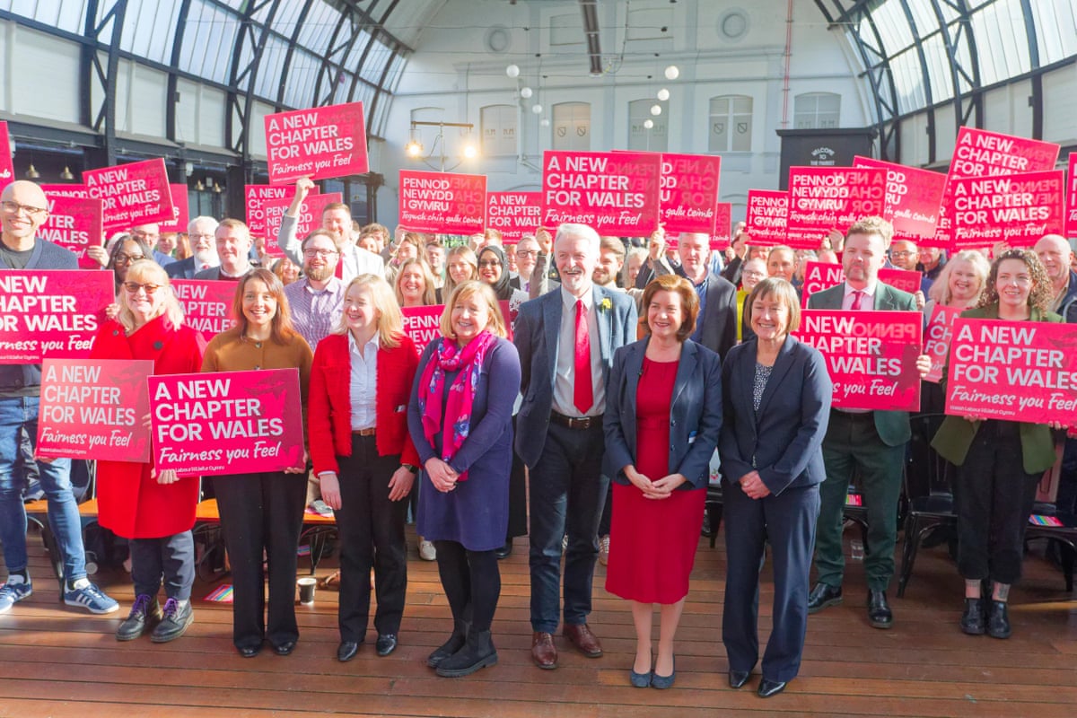 Eluned Morgan with colleagues and supporters who are holding placards that say 'A new chapter for Wales'