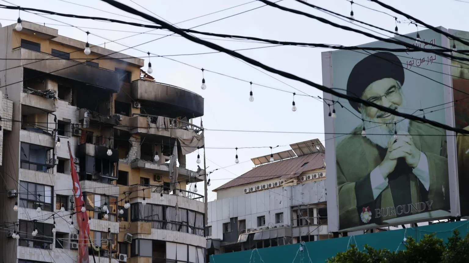 EPA A billboard with a photo of the late Hezbollah leader Hassan Nasrallah is seen near a damaged building following an Israeli airstrike in the southern Beirut suburb of Haret Hreik, Lebanon (02 March 2026)