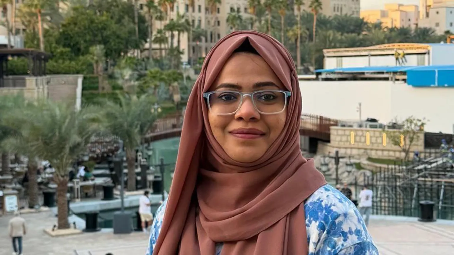 Handout Afsha Farooqui smiles at the camera. She has a brown headscarf on and glasses.