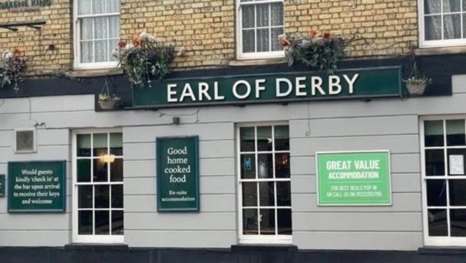 Robbie Kalus/BBC The Earl of Derby pub: a brown and grey building with white-framed windows. The words