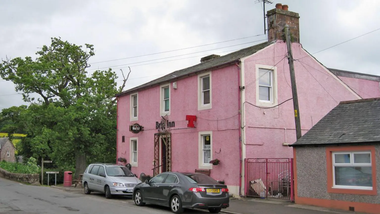 Richard Dorrell The Brig Inn some years ago with cars parked outside and a pink frontage and signs for different types of beer sticking out from the front wall