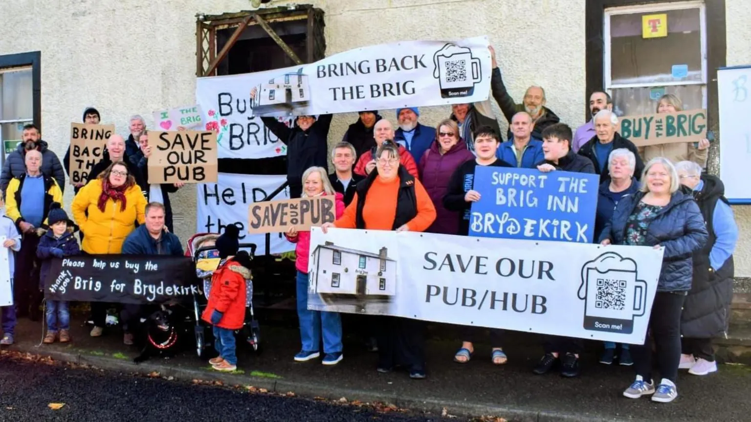 The Brig Inn Pub & Hub Members of the Brydekirk community gathered in front of the former pub holding an array of banners titled with slogans such as 'save our pub/hub'.