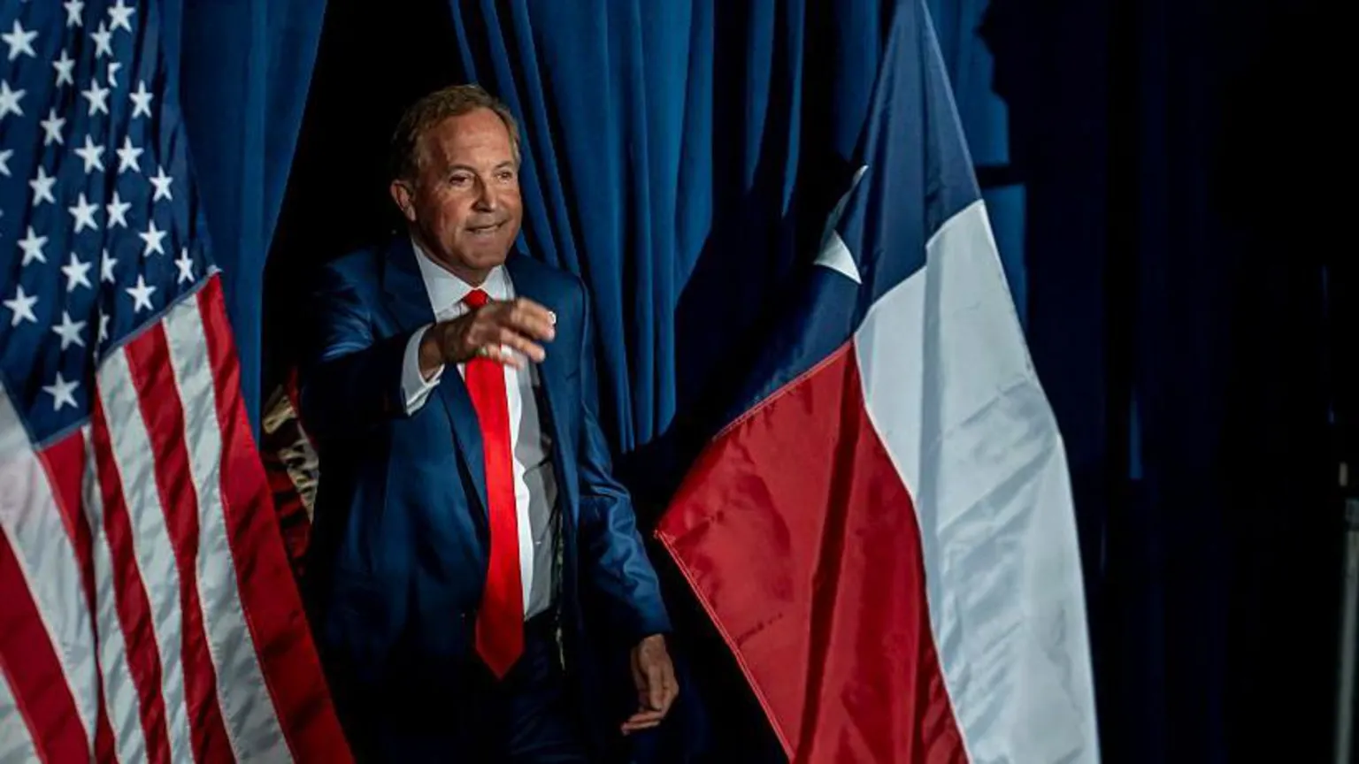  Ken Paxton greets supporters in front of an American flag on election night in Texas