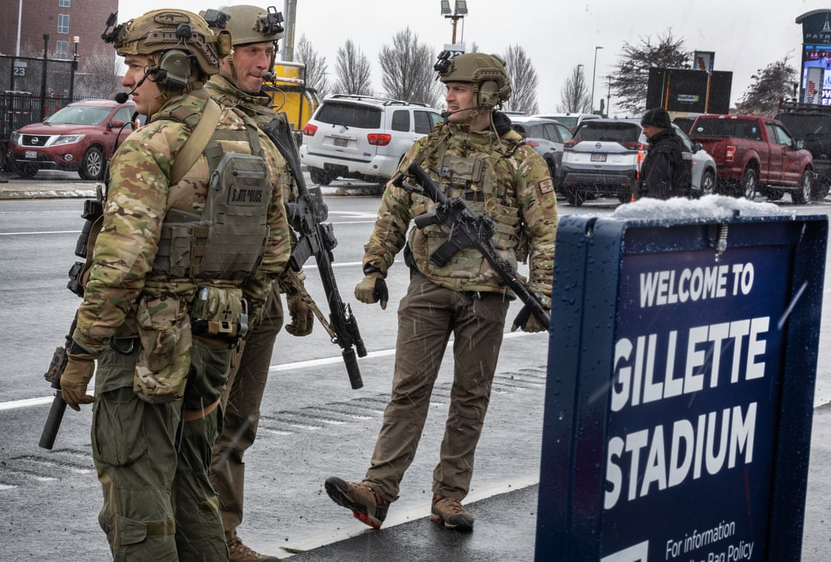 Massachusetts State Police, in military uniforms and toting rifles, patrol outside of Gillette Stadium on December 14, 2025.