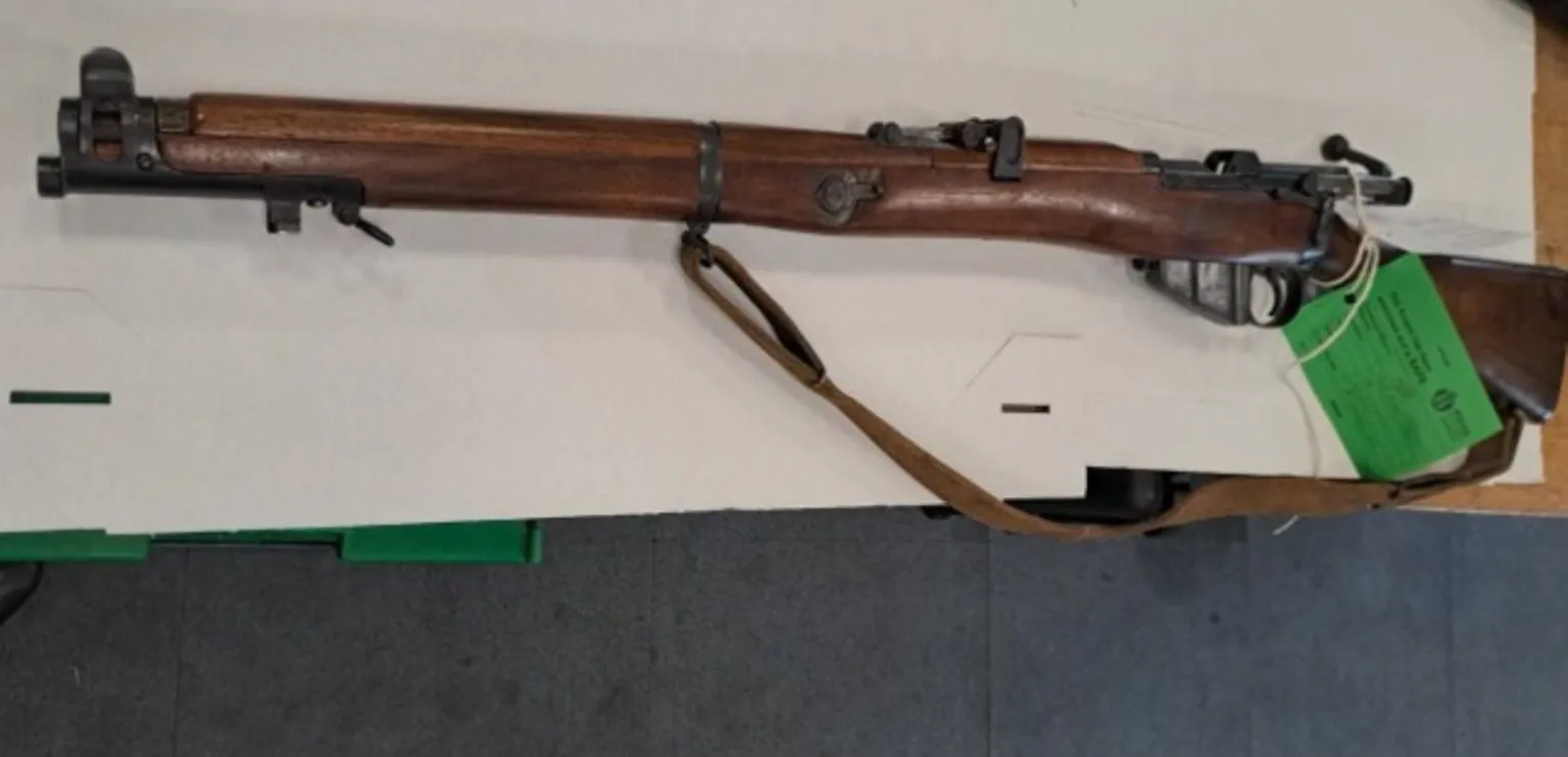 Crown Office and Procurator Fiscal Service A long wooden rifle with a green evidence tag on it