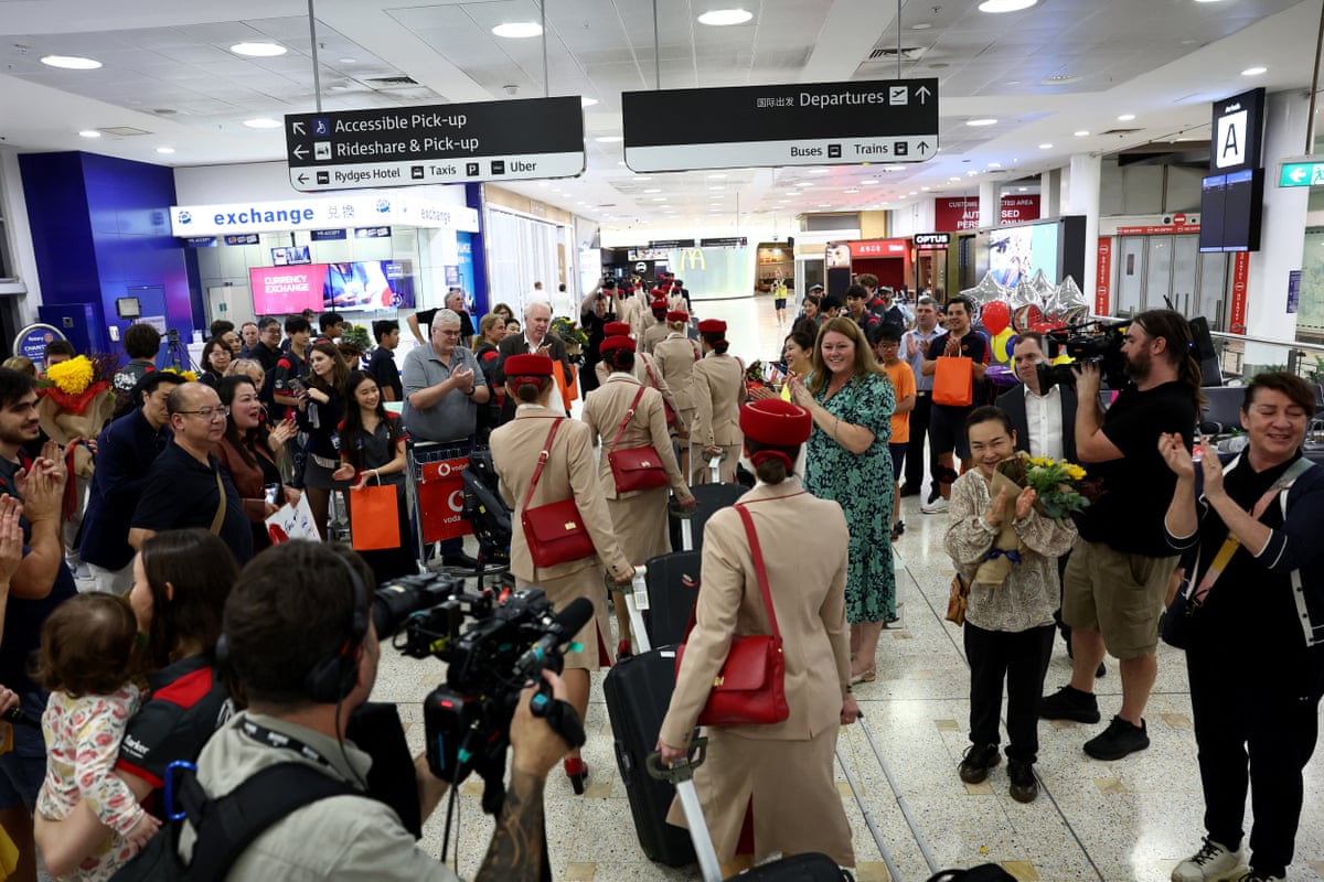 Families and friends of the passengers cheer Emirates crew members after their arrival on a flight from Dubai at Sydney international airport on Wednesday.
